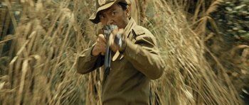 Movie still from “Rambo” (2008), directed by Sylvester Stallone – A man holding a gun in his hands; Medium shot, Low angle
