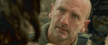 Movie still from “Rambo” (2008), directed by Sylvester Stallone – A man with a beard looking at the camera; Close Up shot, Over the shoulder angle