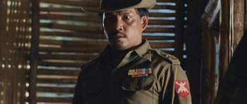 Movie still from “Rambo” (2008), directed by Sylvester Stallone – A man wearing a uniform and a hat; Close Up shot, Low angle