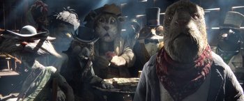 Movie still from “Rango” (2011), directed by Gore Verbinski – A group of cats dressed up like a cowboy and a cowgirl are sitting at a table; Close Up shot, Low angle