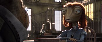 Movie still from “Rango” (2011), directed by Gore Verbinski – A woman sitting at a table in a room; Close Up shot, Over the shoulder angle