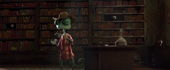 Movie still from “Rango” (2011), directed by Gore Verbinski – A green lizard wearing a cowboy hat in front of a bookshelf; Wide shot, Over the shoulder angle