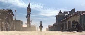 Movie still from “Rango” (2011), directed by Gore Verbinski – A man riding a horse down the middle of a dirt road; Extreme Wide shot, Low angle