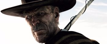 Movie still from “Rango” (2011), directed by Gore Verbinski – An old man wearing a cowboy hat and holding a rifle; Close Up shot, Low angle