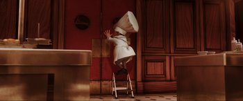 Movie still from “Ratatouille” (2007), directed by Jan Pinkava – A person standing on top of a step ladder wearing a chef's hat; Medium shot, Low angle