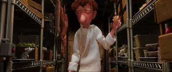 Movie still from “Ratatouille” (2007), directed by Jan Pinkava – An animated character in a kitchen holding a piece of food; Close Up shot, High angle