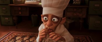 Movie still from “Ratatouille” (2007), directed by Jan Pinkava – An animated character wearing a chef's hat and holding a cookie; Close Up shot, High angle