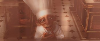 Movie still from “Ratatouille” (2007), directed by Jan Pinkava – An animated character in a chef's outfit kneeling down; Close Up shot, Low angle