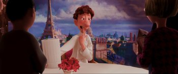 Movie still from “Ratatouille” (2007), directed by Jan Pinkava – A man sitting at a table in front of a painting of a city; Medium shot, Over the shoulder angle