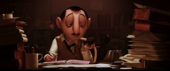 Movie still from “Ratatouille” (2007), directed by Jan Pinkava – An animated man sitting at a desk holding a phone; Medium shot, Low angle