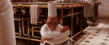 Movie still from “Ratatouille” (2007), directed by Jan Pinkava – An animated character in a chef's outfit sitting in front of an oven; Medium shot, High angle