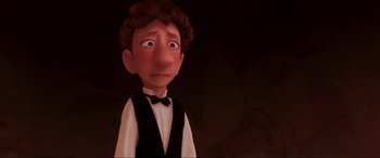 Movie still from “Ratatouille” (2007), directed by Jan Pinkava – An animated man in a black shirt and a black bow tie; Close Up shot, Over the shoulder angle