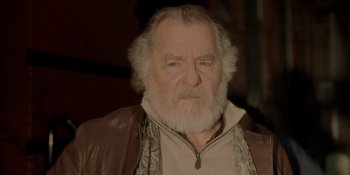 Movie still from “Ray Donovan: The Movie” (2022), directed by David Hollander – An old man with a beard and a brown jacket; Close Up shot, Low angle