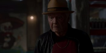 Movie still from “Ray Donovan: The Movie” (2022), directed by David Hollander – An older man wearing a hat and a leather jacket; Close Up shot, Over the shoulder angle