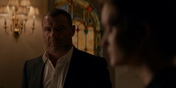 Movie still from “Ray Donovan: The Movie” (2022), directed by David Hollander – A person wearing a suit and tie; Close Up shot, Over the shoulder angle
