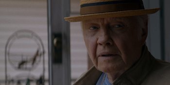 Movie still from “Ray Donovan: The Movie” (2022), directed by David Hollander – An older man wearing a hat and a jacket; Close Up shot, Over the shoulder angle
