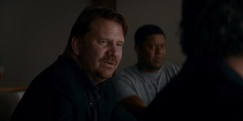 Movie still from “Ray Donovan: The Movie” (2022), directed by David Hollander – Two men are sitting in a dark room; Close Up shot, Over the shoulder angle