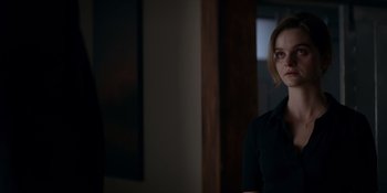 Movie still from “Ray Donovan: The Movie” (2022), directed by David Hollander – A woman in a black shirt is standing in front of a mirror; Medium shot, Over the shoulder angle