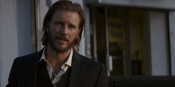 Movie still from “Ray Donovan: The Movie” (2022), directed by David Hollander – A person wearing a suit and tie; Close Up shot, Over the shoulder angle