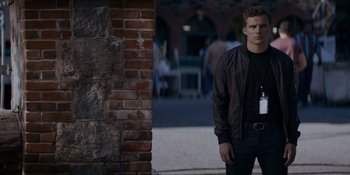 Movie still from “Ray Donovan: The Movie” (2022), directed by David Hollander – A man standing in front of a brick wall; Medium shot, Over the shoulder angle