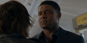 Movie still from “Ray Donovan: The Movie” (2022), directed by David Hollander – A person looking at another person; Close Up shot, Over the shoulder angle