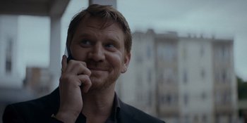 Movie still from “Ray Donovan: The Movie” (2022), directed by David Hollander – A person talking on a cell phone; Close Up shot, Low angle