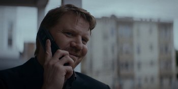 Movie still from “Ray Donovan: The Movie” (2022), directed by David Hollander – A person talking on a cell phone; Close Up shot, Low angle