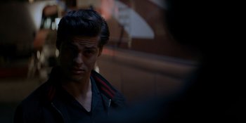 Movie still from “Ray Donovan: The Movie” (2022), directed by David Hollander – A young man with dark hair looking at the camera; Close Up shot, Over the shoulder angle