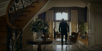Movie still from “Ray Donovan: The Movie” (2022), directed by David Hollander – A man and a woman are walking through a room; Wide shot, Low angle