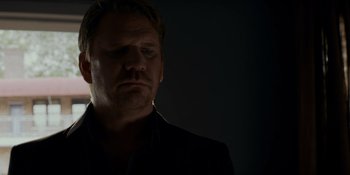 Movie still from “Ray Donovan: The Movie” (2022), directed by David Hollander – A person in a dark room; Close Up shot, Low angle