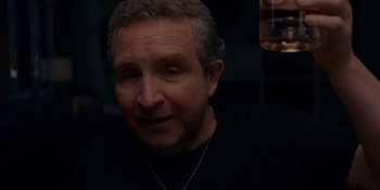 Movie still from “Ray Donovan: The Movie” (2022), directed by David Hollander – A person wearing a black t - shirt; Close Up shot, Low angle