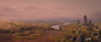 Movie still from “Raya and the Last Dragon” (2021), directed by Don Hall – A person sitting on a hill near a body of water; Extreme Wide shot, High angle