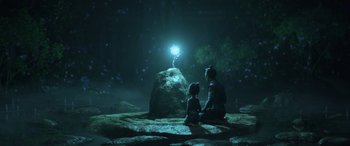 Movie still from “Raya and the Last Dragon” (2021), directed by Don Hall – A man and a little girl sitting in front of a rock; Wide shot, Over the shoulder angle