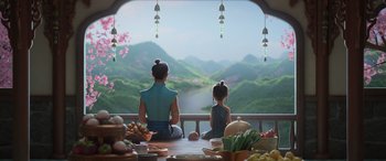 Movie still from “Raya and the Last Dragon” (2021), directed by Don Hall – A woman and a child sitting on a table looking out a window; Wide shot, Over the shoulder angle
