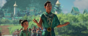 Movie still from “Raya and the Last Dragon” (2021), directed by Don Hall – A man and a boy are standing in front of a group of people; Medium shot, Over the shoulder angle