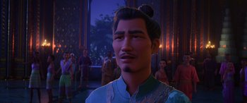 Movie still from “Raya and the Last Dragon” (2021), directed by Don Hall – An asian man in a blue shirt is in front of a group of people; Close Up shot, Over the shoulder angle