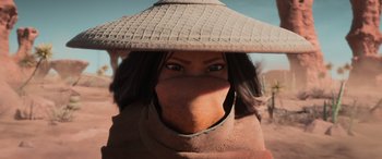 Movie still from “Raya and the Last Dragon” (2021), directed by Don Hall – A woman wearing a straw hat with a face covering; Close Up shot, Low angle