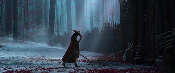 Movie still from “Raya and the Last Dragon” (2021), directed by Don Hall – A person in a red cape and a hat is walking through a forest; Wide shot, Over the shoulder angle