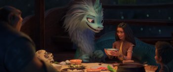 Movie still from “Raya and the Last Dragon” (2021), directed by Don Hall – A woman sitting at a table next to a monster; Medium shot, Over the shoulder angle