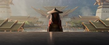 Movie still from “Raya and the Last Dragon” (2021), directed by Don Hall – A woman wearing a hat standing in front of a building; Wide shot, Low angle