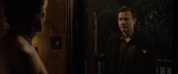 Movie still from “Raymond & Ray” (2022), directed by Rodrigo García – A man standing in front of a wooden door; Medium shot, Over the shoulder angle