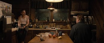 Movie still from “Raymond & Ray” (2022), directed by Rodrigo García – A kitchen with a table and a sink with a lot of food on it; Medium shot, High angle