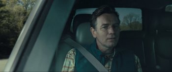 Movie still from “Raymond & Ray” (2022), directed by Rodrigo García – A man sitting in the back seat of a car; Close Up shot, Over the shoulder angle