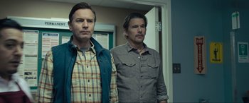 Movie still from “Raymond & Ray” (2022), directed by Rodrigo García – A couple of men standing next to each other in front of a door; Medium shot, Over the shoulder angle