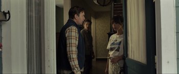 Movie still from “Raymond & Ray” (2022), directed by Rodrigo García – A man and a woman standing in front of another man; Medium shot, Over the shoulder angle