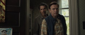 Movie still from “Raymond & Ray” (2022), directed by Rodrigo García – Two men standing next to each other in front of a door; Medium shot, Over the shoulder angle