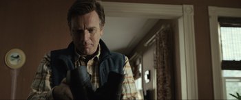 Movie still from “Raymond & Ray” (2022), directed by Rodrigo García – A man wearing a boxing glove in a living room; Close Up shot, Low angle