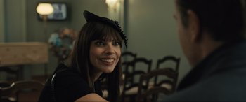 Movie still from “Raymond & Ray” (2022), directed by Rodrigo García – A woman wearing a black cat hat smiling for the camera; Close Up shot, Over the shoulder angle