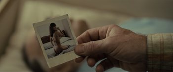 Movie still from “Raymond & Ray” (2022), directed by Rodrigo García – A person holding a picture of a naked woman; Extreme Close Up shot, High angle