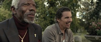 Movie still from “Raymond & Ray” (2022), directed by Rodrigo García – Two men sitting next to each other in front of trees; Close Up shot, Over the shoulder angle